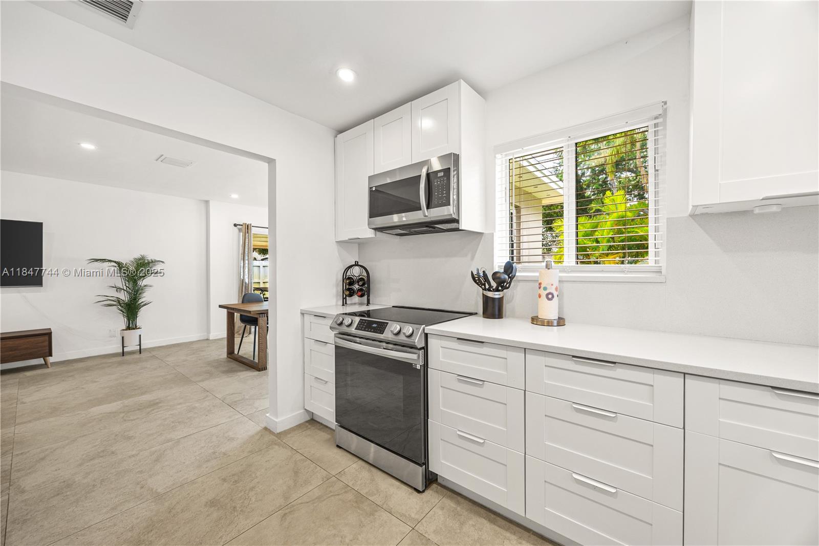 3246 Pierce Street Hollywood, FL 33021 - Photo 8 of 41 a kitchen with white cabinets and stainless steel appliances