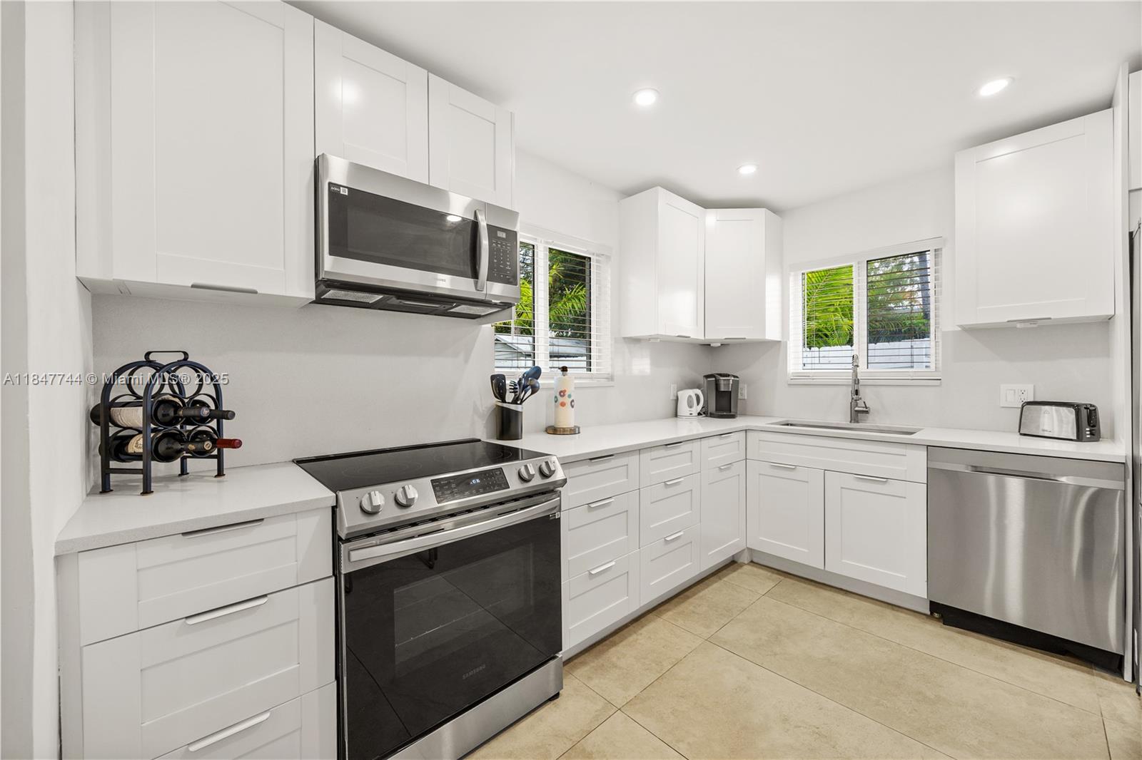 3246 Pierce Street Hollywood, FL 33021 - Photo 9 of 41 a kitchen with stainless steel appliances granite countertop white cabinets a sink and a stove