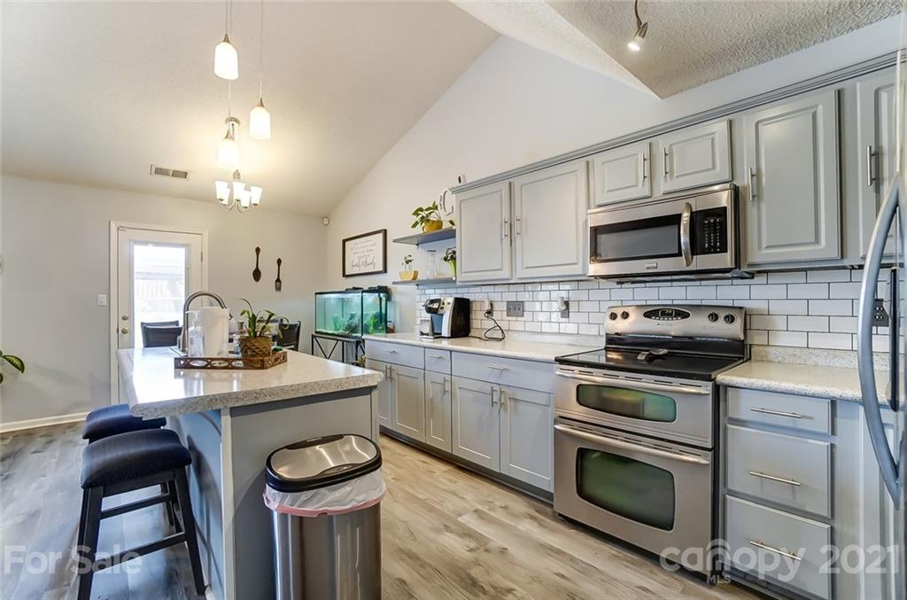 7034 Blithe Low Place Charlotte, NC 28273 - Photo 11 of 31 a kitchen with a stove a sink and a microwave