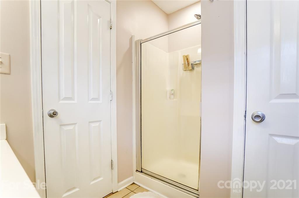 7034 Blithe Low Place Charlotte, NC 28273 - Photo 19 of 31 a bathroom with a glass shower door