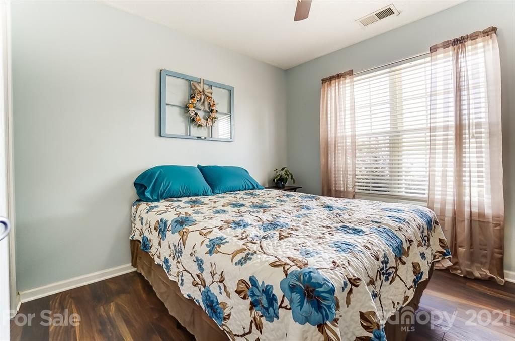 7034 Blithe Low Place Charlotte, NC 28273 - Photo 23 of 31 a bedroom with a bed and wooden floor