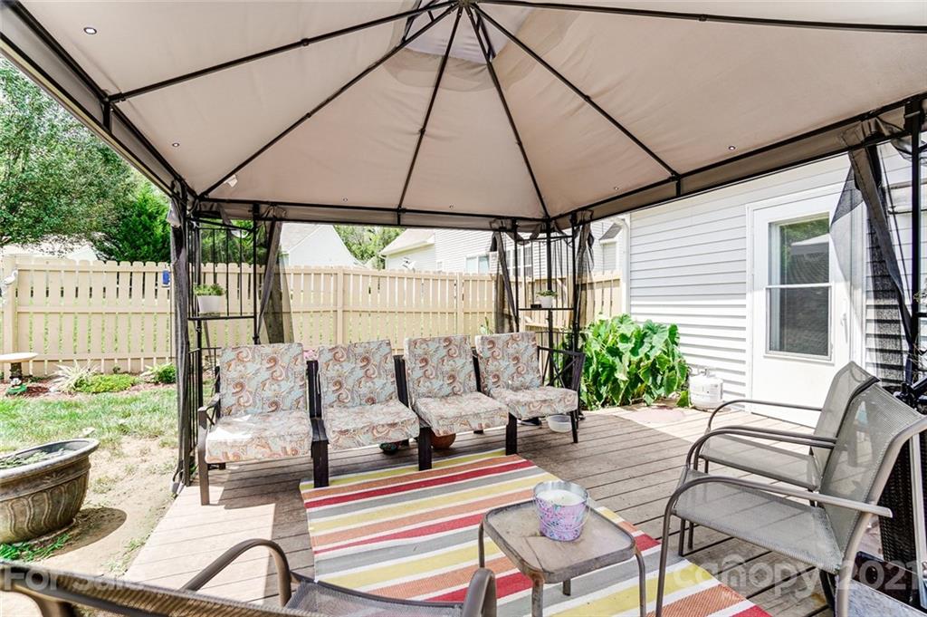 7034 Blithe Low Place Charlotte, NC 28273 - Photo 30 of 31 a view of patio with a table and chairs under an umbrella