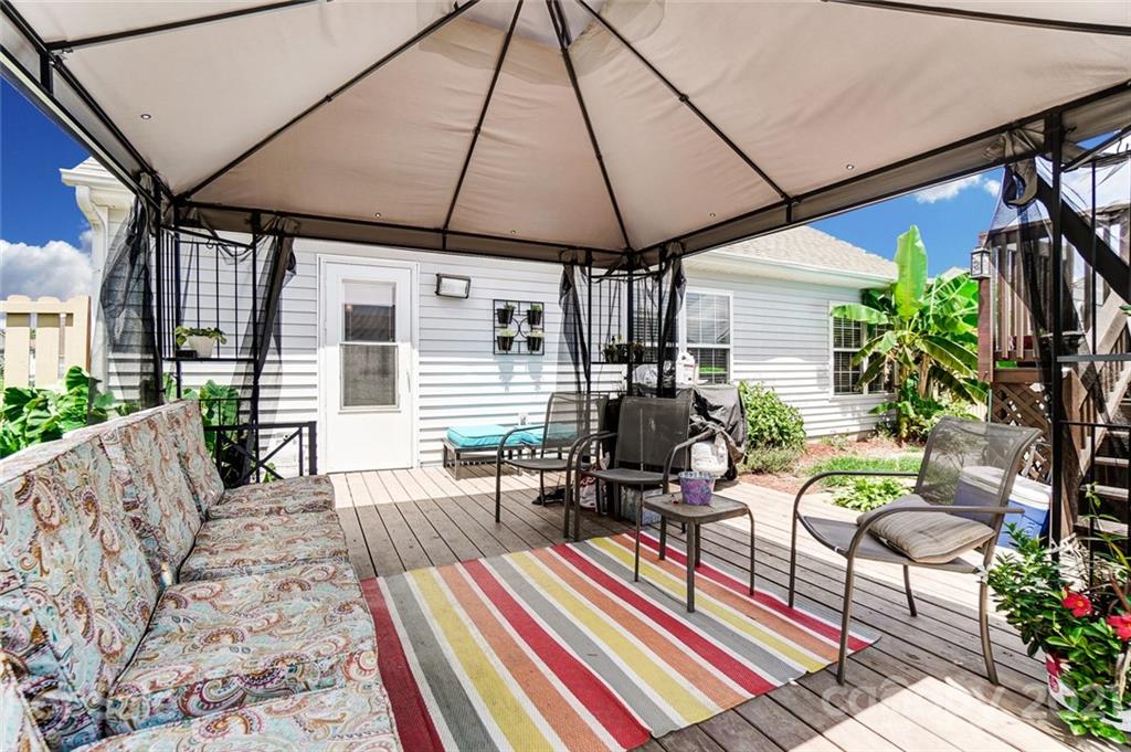 7034 Blithe Low Place Charlotte, NC 28273 - Photo 31 of 31 a view of a patio with couches and chairs under an umbrella