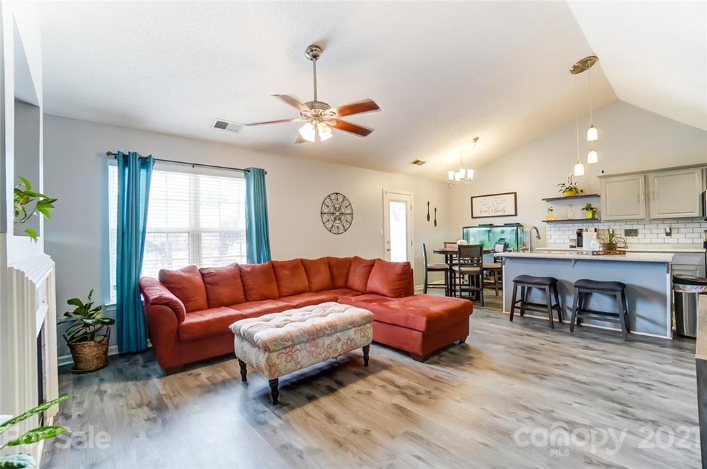 7034 Blithe Low Place Charlotte, NC 28273 - Photo 6 of 31 a living room with furniture kitchen view and a wooden floor