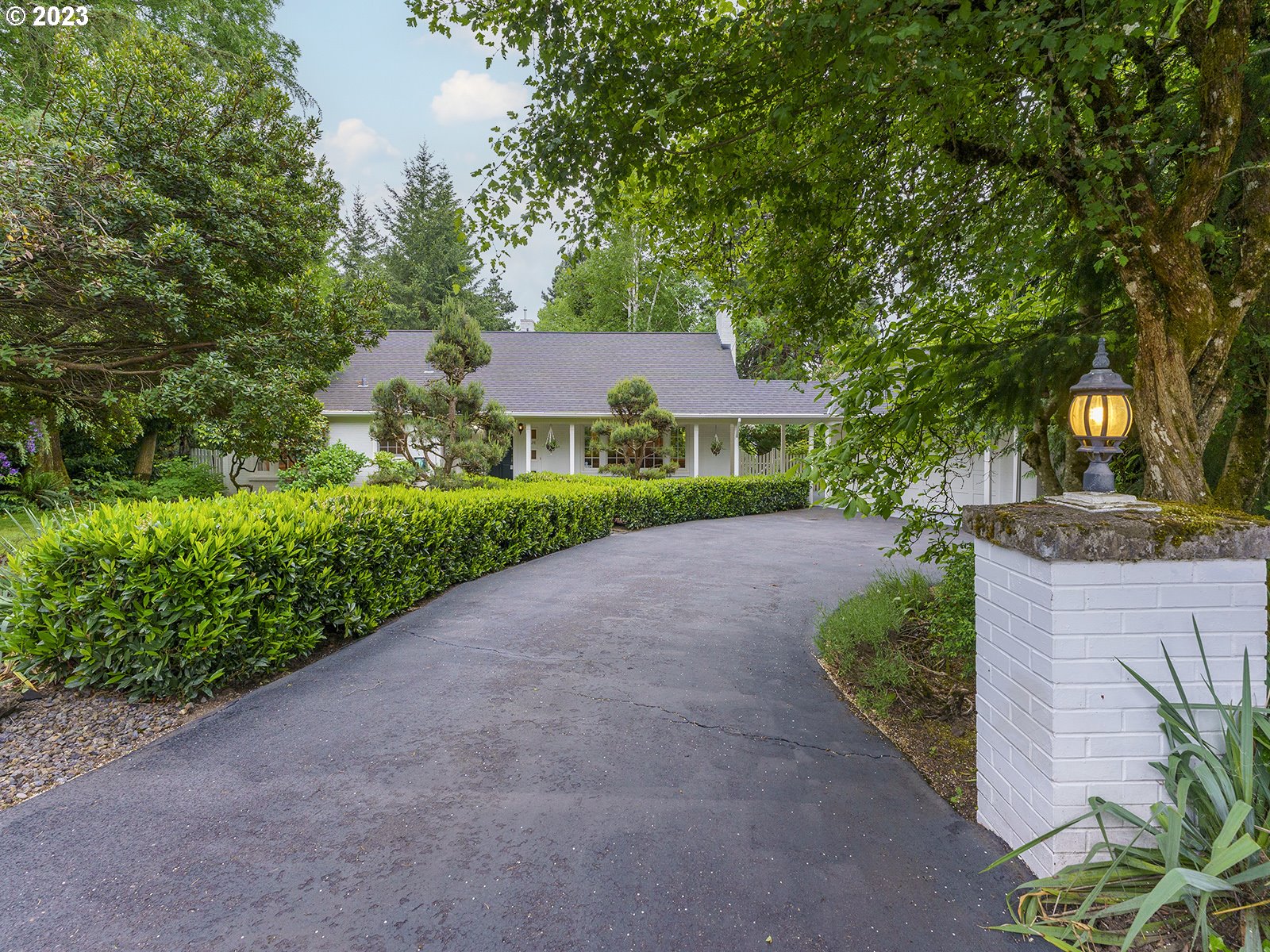 a front view of a house with a yard and shrubs