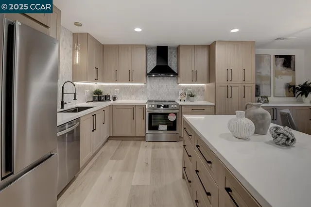 a open kitchen with stainless steel appliances granite countertop a sink stove and refrigerator