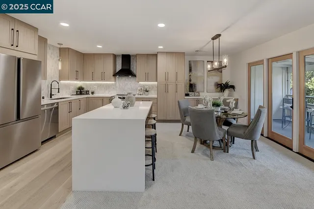 a kitchen with refrigerator a sink and chairs