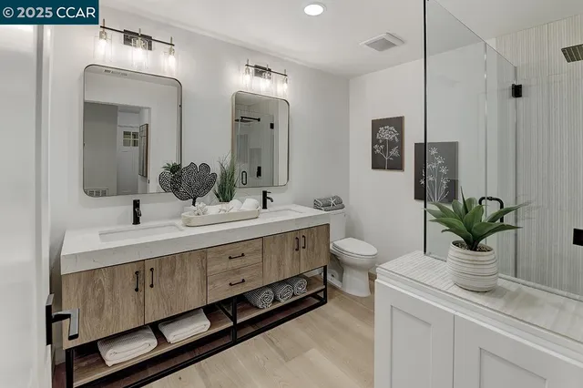 a bathroom with a double vanity sink a toilet and a mirror