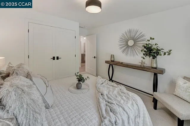 a bedroom with a bed and a potted plant on the dresser