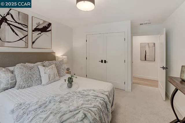 a bed room with a bed a couch and chandelier