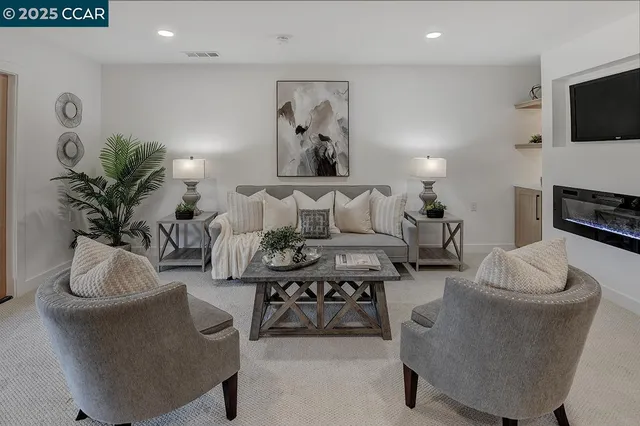 a living room with furniture a flat screen tv and a fireplace