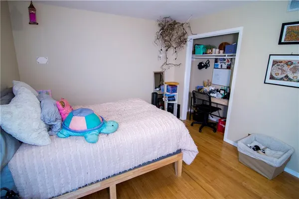 a bedroom with a bed and wooden floor