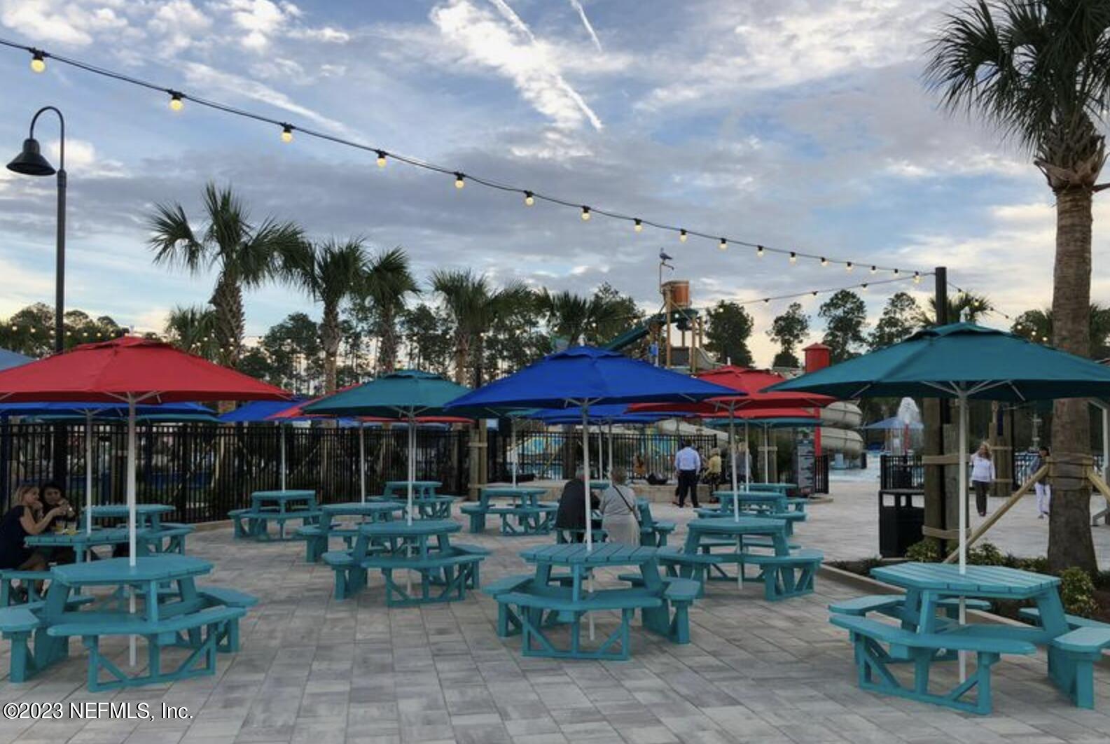 141 Pelican Pointe Road Ponte Vedra, FL 32081 - Photo 69 of 80 a view of a chairs and table under an umbrella in patio with a barbeque