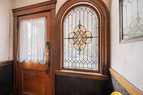 a view of wooden door with windows and brick walls