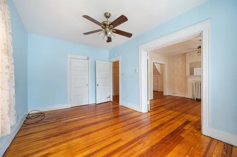 a view of a livingroom with wooden floor and a ceiling fan