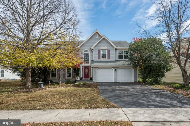 a front view of a house with a yard and trees