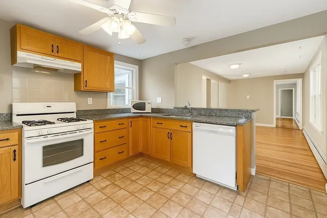 a kitchen with granite countertop a sink stove and cabinets