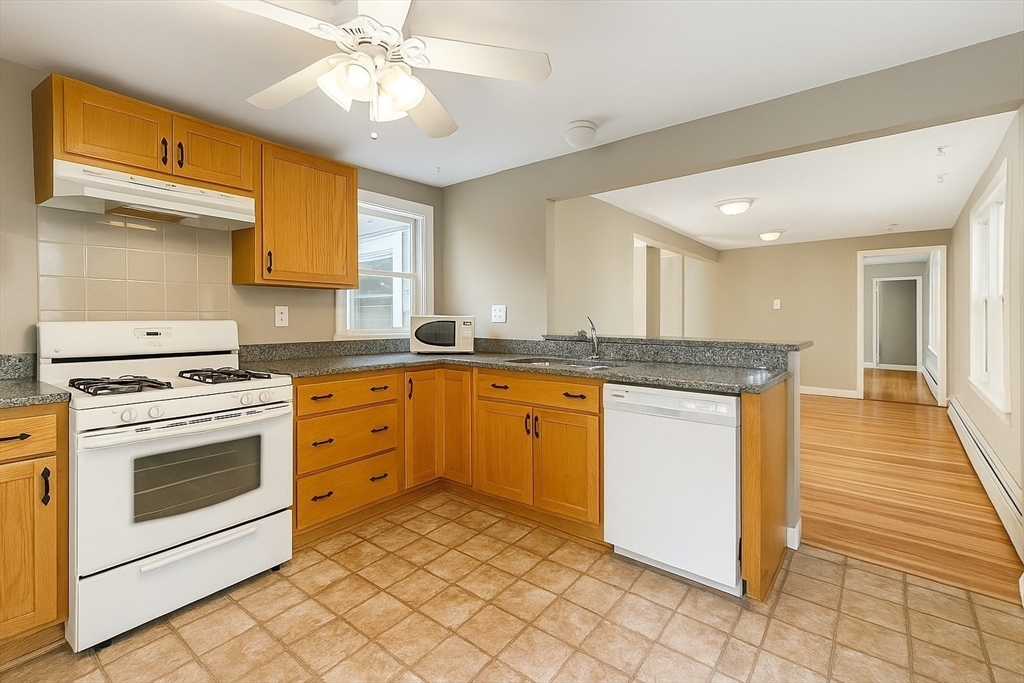 a kitchen with granite countertop a sink stove and cabinets