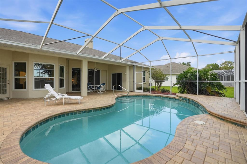 14228 Presteign Lane Spring Hill, FL 34609 - Photo 65 of 89 a view of a patio with dining table and chairs under an umbrella