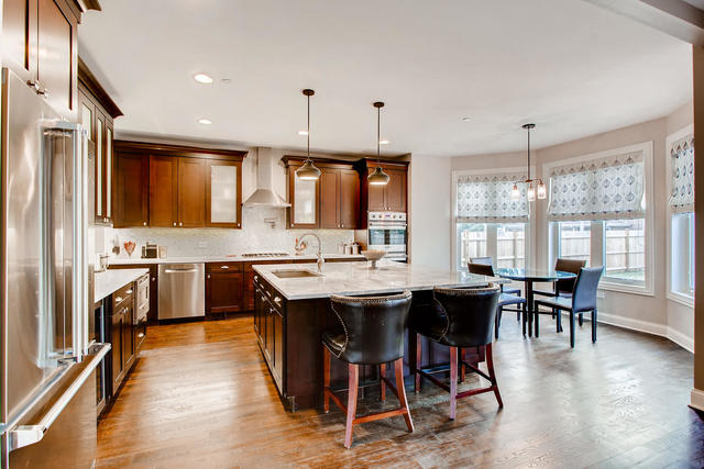 462 Northgate Court Riverside, IL 60546 - Photo 8 of 36 a kitchen with stainless steel appliances granite countertop a stove a refrigerator a kitchen island a dining table and chairs with wooden floor