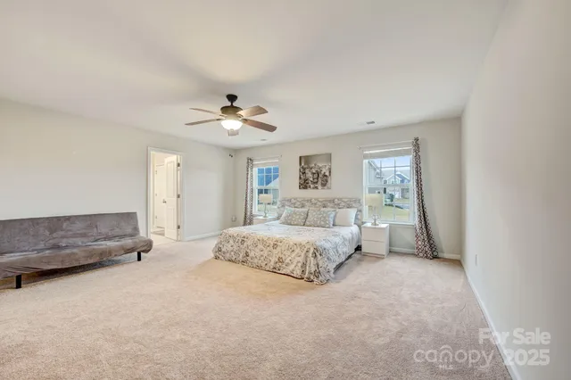 a spacious bedroom with a large bed and a chandelier