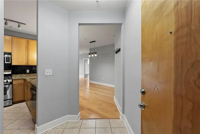 a view of a hallway view with wooden floor and a bathroom