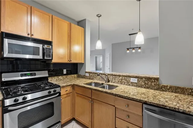 a kitchen with granite countertop a sink a stove and microwave