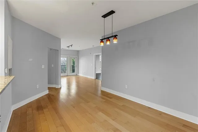 a view of an empty room with window and wooden floor