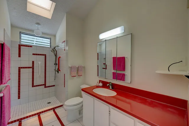 a bathroom with a sink toilet vanity and shower