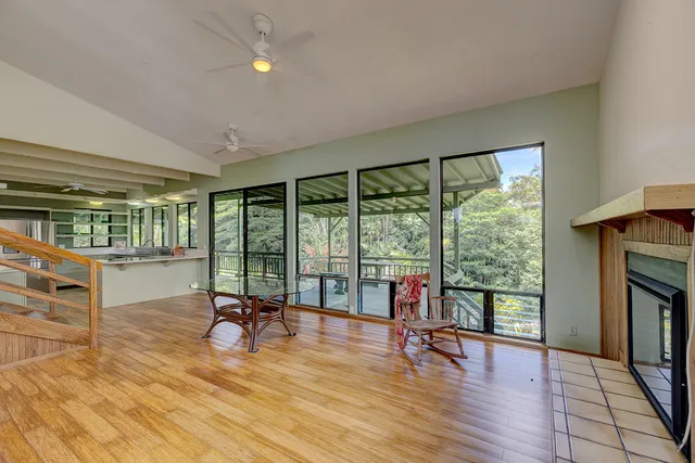 a living room with furniture floor to ceiling window and wooden floor