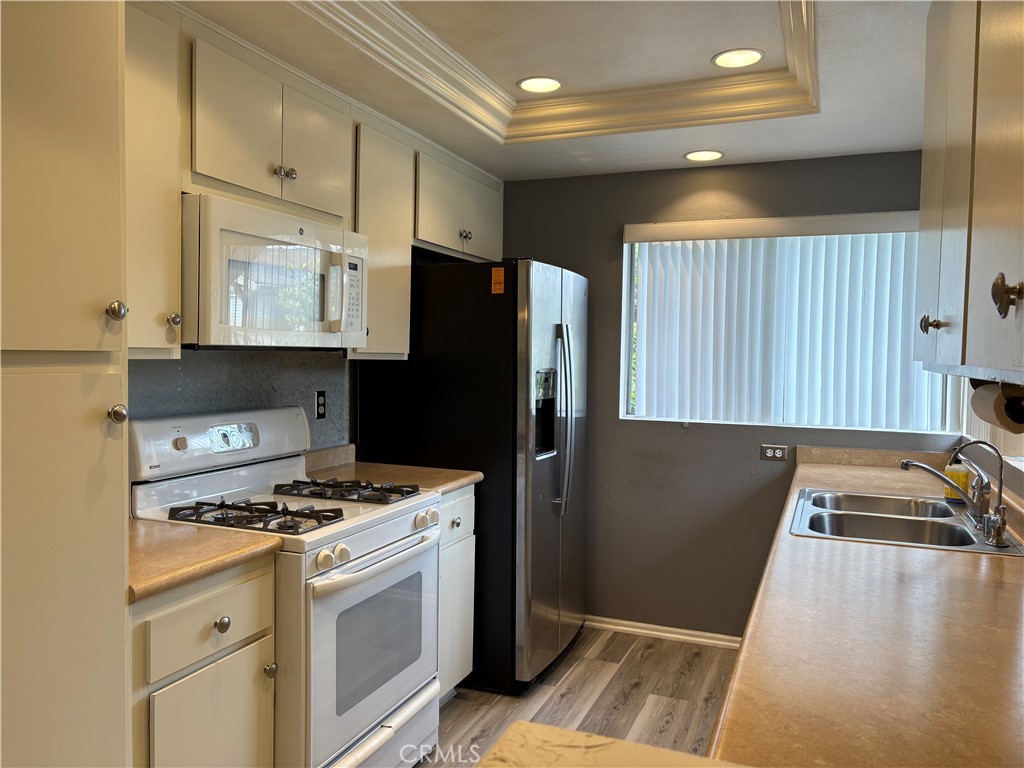 70 Echo Run, Unit 31 Irvine, CA 92614 - Photo 6 of 19 a kitchen with a refrigerator and a sink