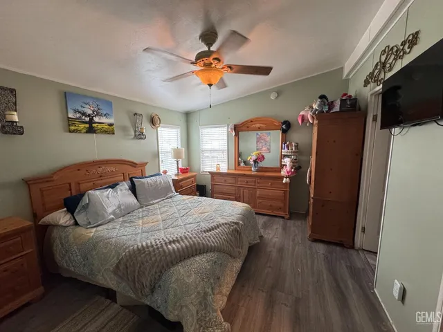 a bedroom with a bed and a flat tv screen on dresser