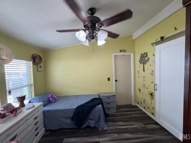 a bedroom with a bed chandelier and a window