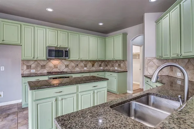 a kitchen with a sink stove and cabinets