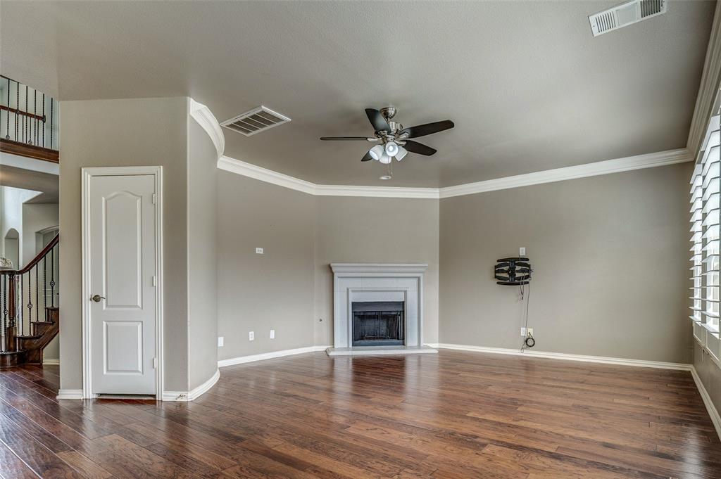 916 Carlsbad Drive Allen, TX 75002 - Photo 13 of 34 a view of an empty room with wooden floor and a ceiling fan
