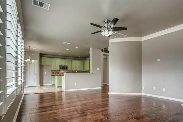 a view of empty room with wooden floor and window