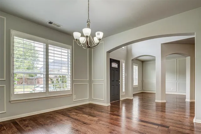 a view of a room with wooden floor and chandelier