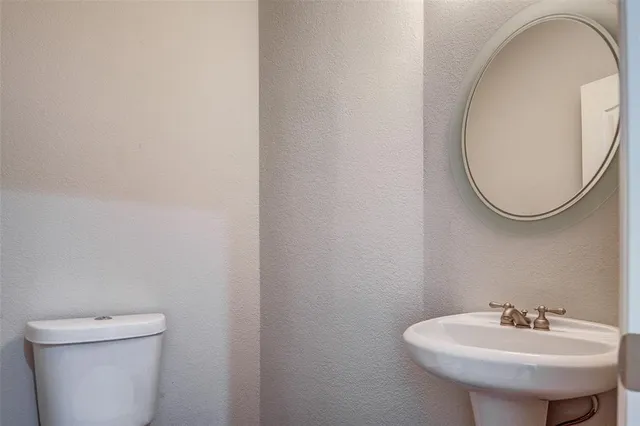 a bathroom with a sink a mirror and a toilet