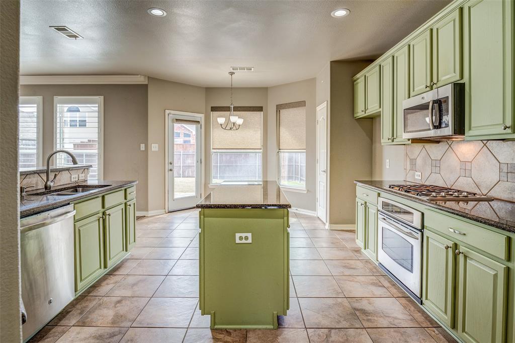 916 Carlsbad Drive Allen, TX 75002 - Photo 9 of 34 a kitchen with stainless steel appliances granite countertop a stove a sink and a microwave