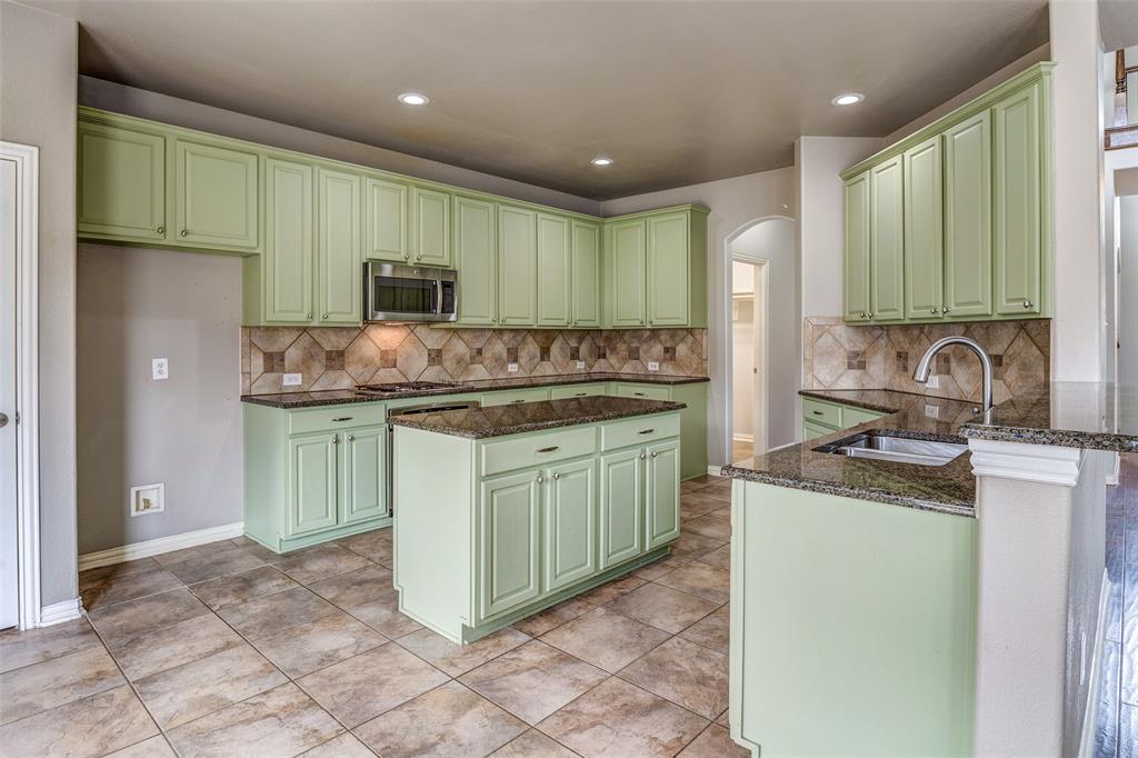 916 Carlsbad Drive Allen, TX 75002 - Photo 10 of 34 a kitchen with a sink stove and cabinets