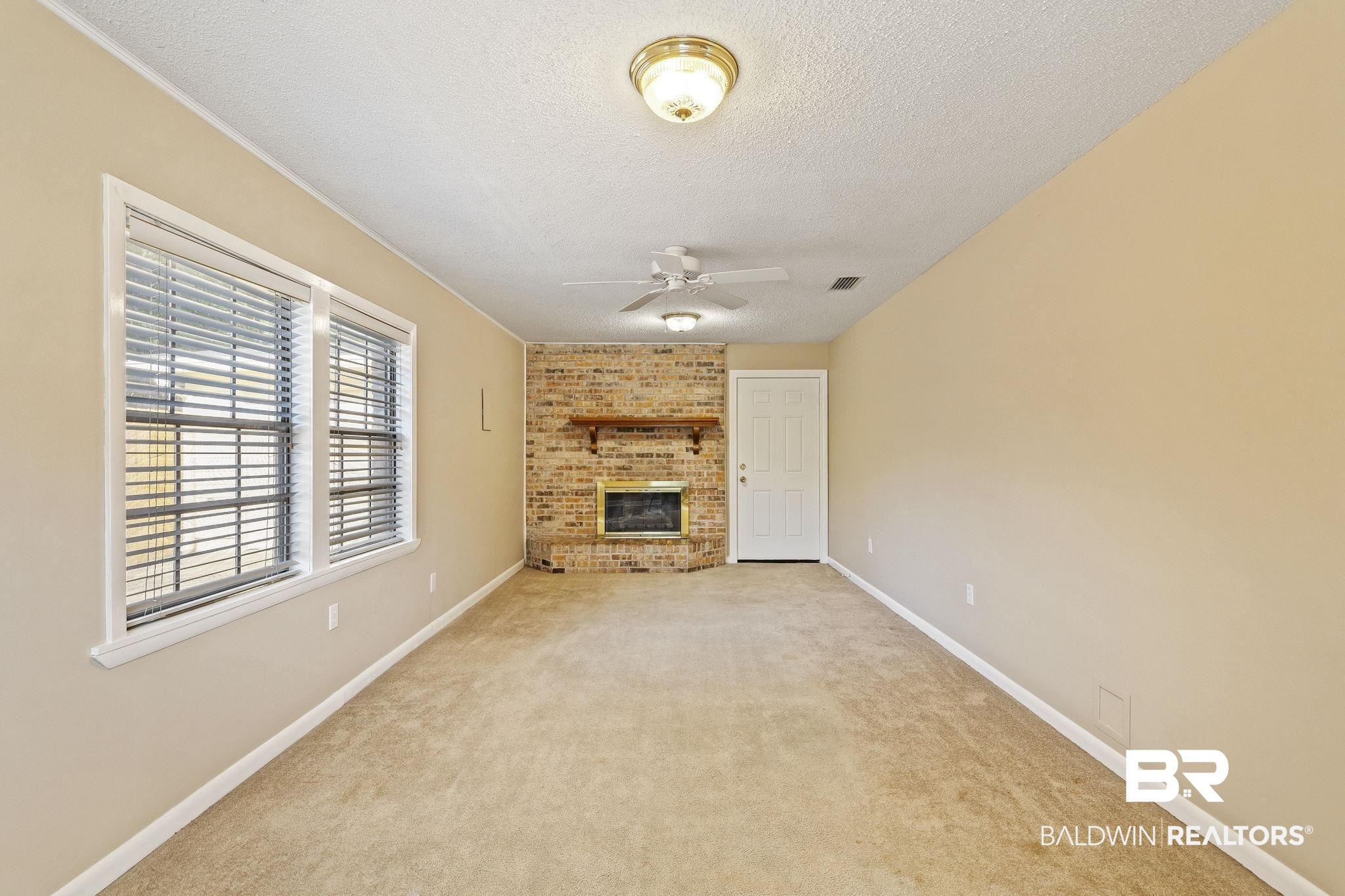 4366 Barden Avenue Mobile, AL 36619 - Photo 16 of 40 Unfurnished living room with a brick fireplace, light colored carpet, a textured ceiling, and ceiling fan