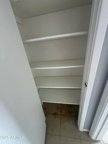 an empty room with a ceiling fan and window