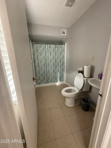 a bathroom with a shower a toilet and sink