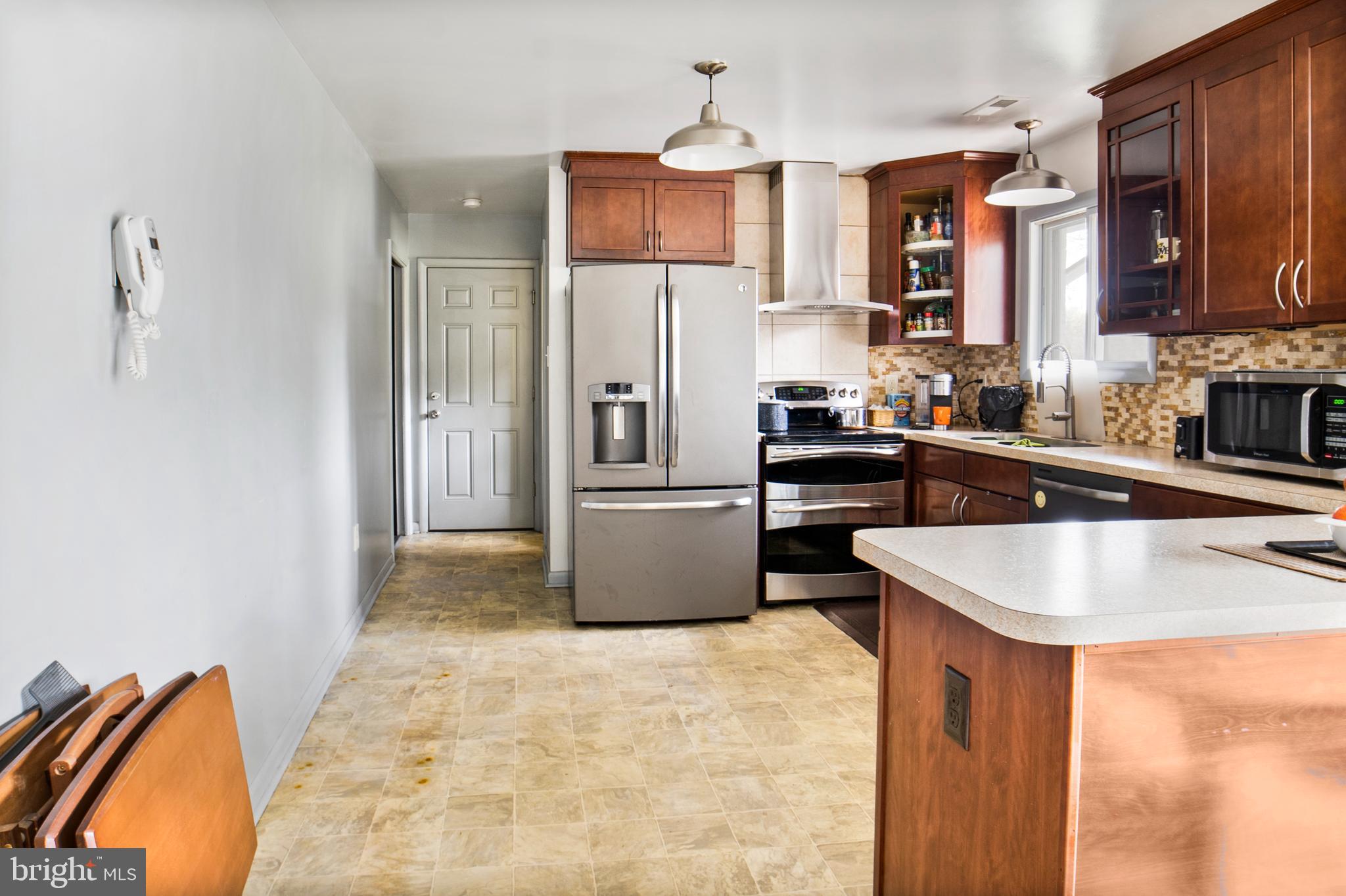 12323 Lanham Severn Road Bowie, MD 20720 - Photo 6 of 20 a kitchen with stainless steel appliances granite countertop a sink and a refrigerator