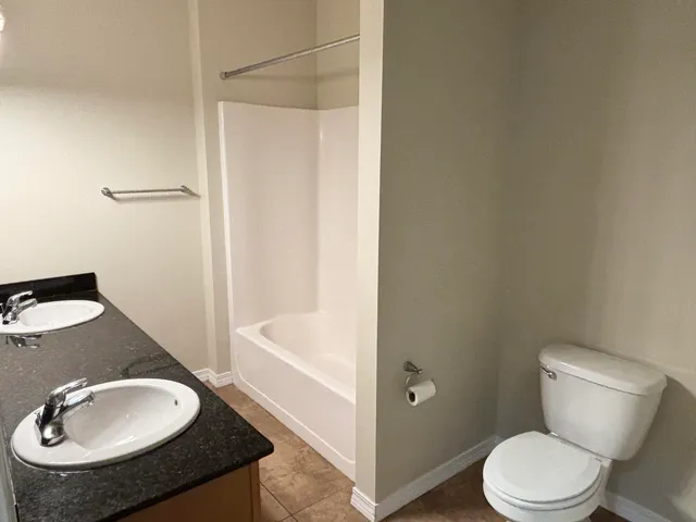 a bathroom with a granite countertop sink toilet and a mirror
