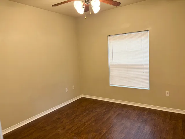 an empty room with wooden floor and a window