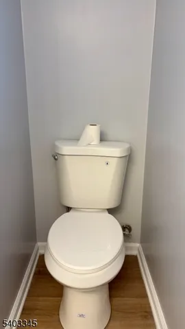 a white toilet sitting next to a white cabinet