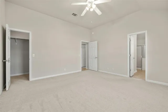 a view of an empty room with a chandelier fan