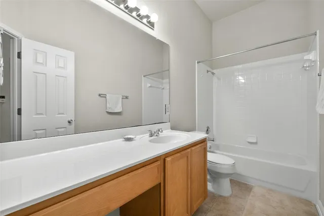 a spacious bathroom with a bathtub shower sink mirror and toilet