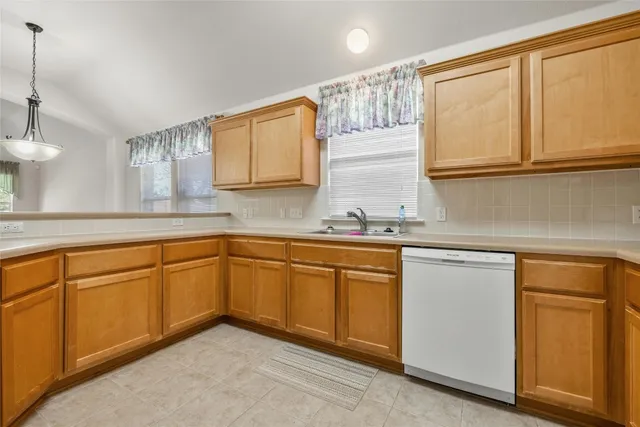 a kitchen with granite countertop stainless steel appliances white cabinets sink and a granite counter top